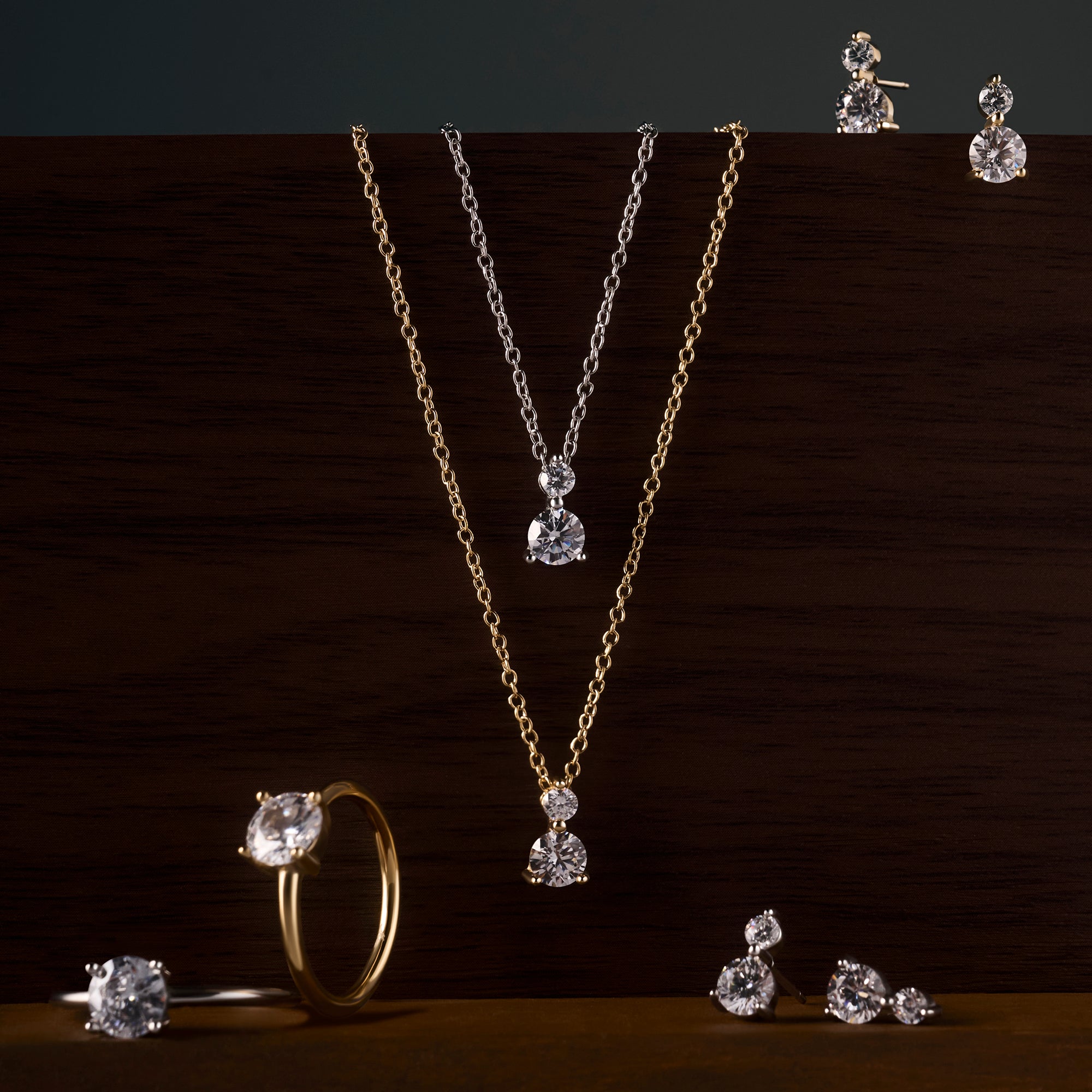 Solitaire cubic zirconia jewelry collection with gold and silver stainless steel pendant necklaces, stud earrings and matching ring, classic elegant pieces with brilliant diamond-like stones.