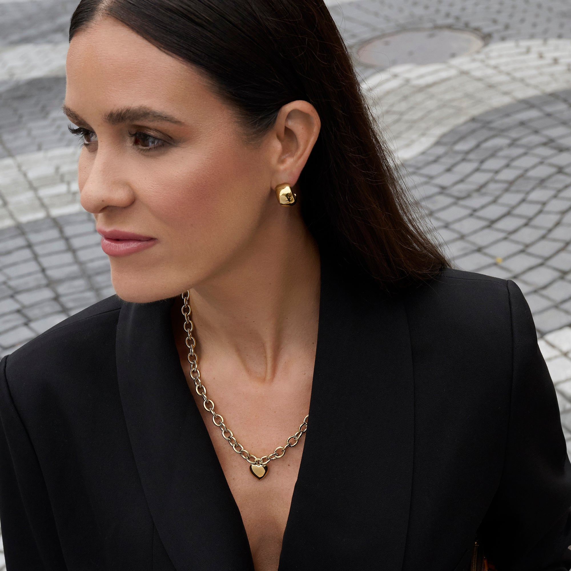 Gold stainless steel chunky chain necklace with heart pendant worn with gold statement stud earrings, bold elegant jewelry look, hypoallergenic non-tarnish durable everyday jewelry, modern minimalist fashion jewelry.

